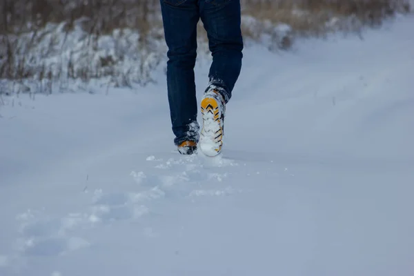 Walking man in winter steps and footprints of a man in the winter forest, winter shoes