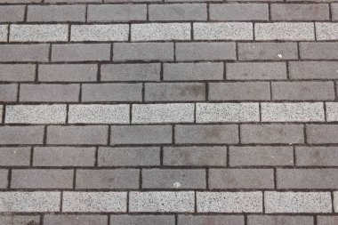 Wall made of broken gray and white bricks in a horizontal plane