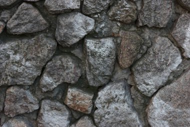 wall is made of gray-black stone, the stones are distributed randomly