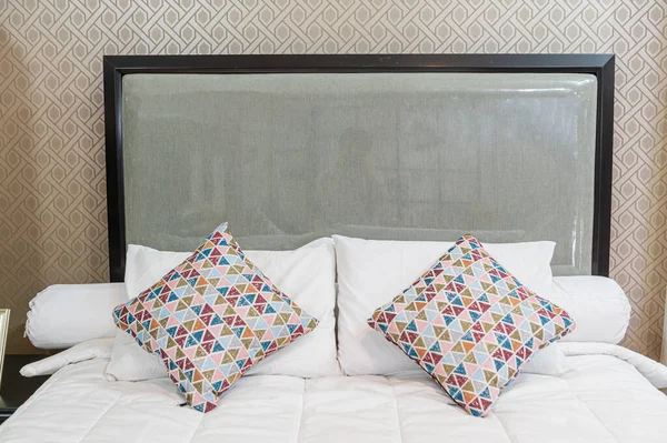 Beyaz Çarşaflı Yatak Eşsiz Bir Deseni Olan Iki Yastık — Stok fotoğraf