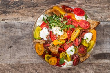Domatesli salata ve lahanalı Burrata peyniri ve ahşap arka planda zeytinyağı.