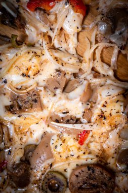 Yakın plan çekimde bir dilim vejetaryen pizzayı soğan, dolmalık biber ve sebzelerle ahşap bir tahtada alıyorum. Güzel.