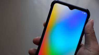 İnsan eli siyah akıllı telefonu boş ekranda tutuyor, renkli..