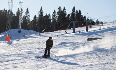 Umea, Norrland İsveç - 19 Şubat 2022: arka planda kayakla tepeden kayak yapan adam