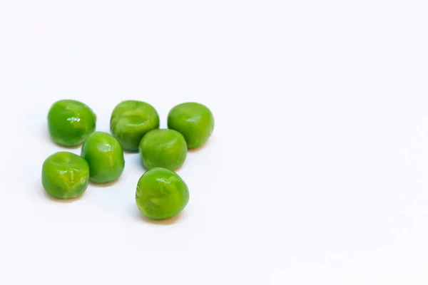 白い背景に緑のエンドウ豆が数個あり — ストック写真