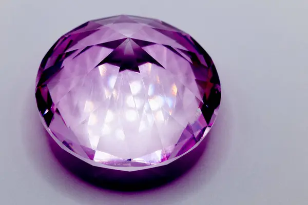 a purple diamond in glass for children to play with on light background