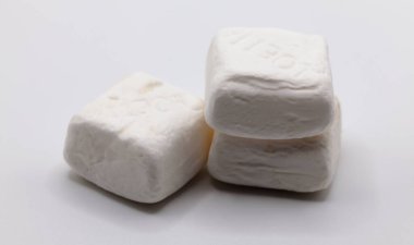 Tarafsız bir zeminde biriken el değmemiş beyaz marşmelovlar yumuşak, yastık gibi dokularını sergiliyor..