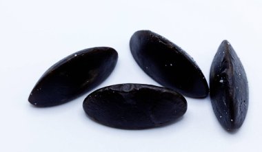 Beyaz yüzeyde sıralanmış siyah oval şekilli meyan kökü şekeri koleksiyonu