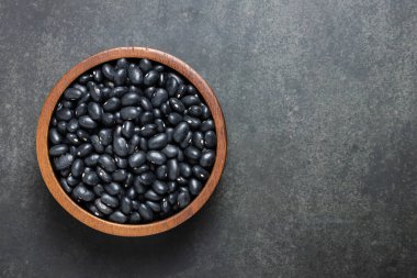 Siyah arka planda, tahta kasede siyah fasulye.