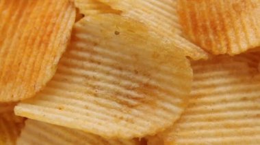 Dalgalı gevrek patates cipsi dönüyor. Yakın çekim.
