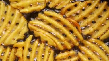 Waffle kızartmalarının üst görüntüsü kızgın yağda kızarır.