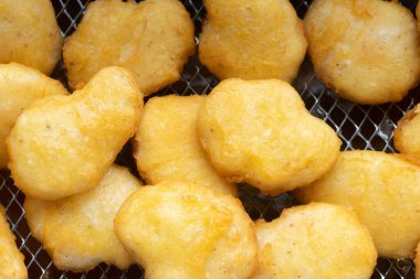Kızarmış tavuk nuggetlarının üst görüntüsü fritöz sepetinde