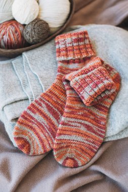 Elle örülmüş çoraplar, iğneler ve iplik yumağı. El yapımı ve yavaş yaşam için higge kavramı.