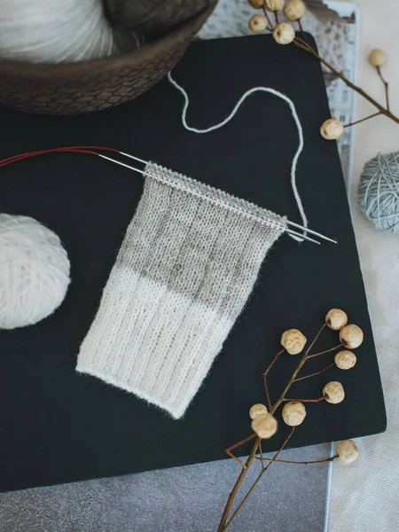 黒い背景に針と糸玉で編んだ靴下を手で編む 手作りと巨大なスローライフのための概念 — ストック写真