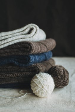 Arka planda iplik topları olan el yapımı çoraplar. El yapımı ve yavaş yaşam için higge kavramı.