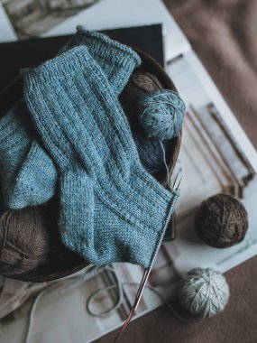 Arka planda iplik topları olan el yapımı çoraplar. El yapımı ve yavaş yaşam için higge kavramı.