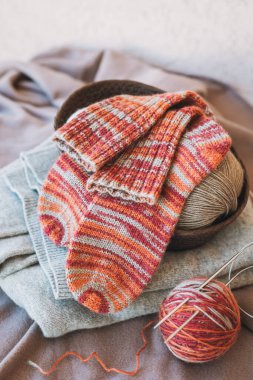 Elle örülmüş çoraplar, iğneler ve iplik yumağı. El yapımı ve yavaş yaşam için higge kavramı.