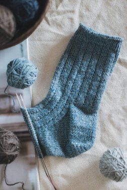 Arka planda iplik topları olan el yapımı çoraplar. El yapımı ve yavaş yaşam için higge kavramı.