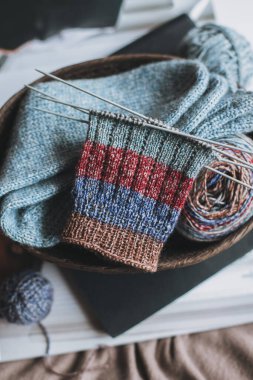 El örgüsü çoraplar, iğneler ve iplik yumağı sepette. El yapımı ve yavaş yaşam için higge kavramı.