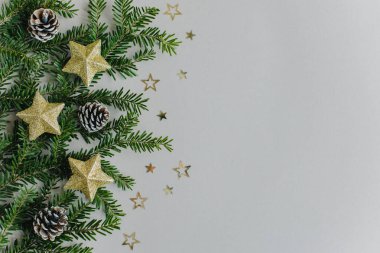 Gri arka planda güzel Noel süsleri ve ladin dalları. Düz yatıyordu. Metin için yer.