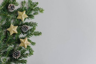 Gri arka planda güzel Noel süsleri ve ladin dalları. Düz yatıyordu. Metin için yer.