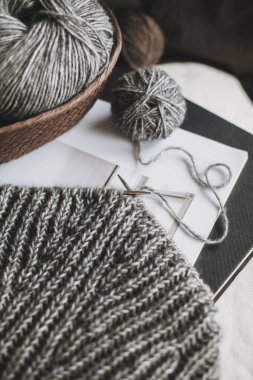 Hand knitting with needles and yarn balls on a table. Concept for handmade and hygge slow life.
