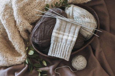 El örgüsü çoraplar, iğneler ve iplik yumağı sepette. El yapımı ve yavaş yaşam için higge kavramı.