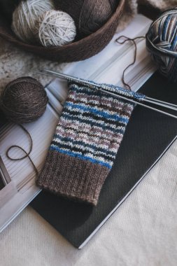 Hand knitted socks with needles and yarn balls. Concept for handmade and hygge slow life.