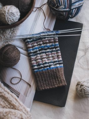 Hand knitted socks with needles and yarn balls. Concept for handmade and hygge slow life.