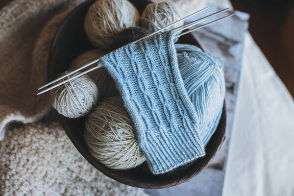 Рука вязаные носки с иголками и пряжи мяч в корзине. Мбаппе для ручной работы и гипермедленной жизни.