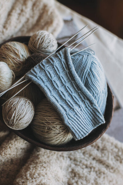 Рука вязаные носки с иголками и пряжи мяч в корзине. Мбаппе для ручной работы и гипермедленной жизни.