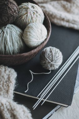 Balls of wool yarn and needles for hand knitting in a basket. Concept for handmade. Place for text.