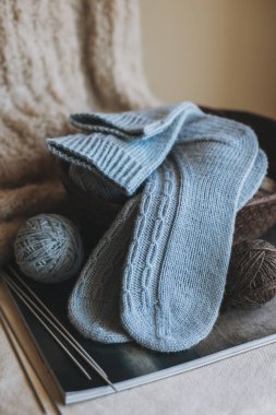 El örgüsü çoraplar, iğneler ve iplik yumağı sepette. El yapımı ve yavaş yaşam için higge kavramı.