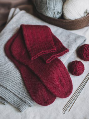 Elle örülmüş çoraplar, iğneler ve iplik yumağı. El yapımı ve yavaş yaşam için higge kavramı.