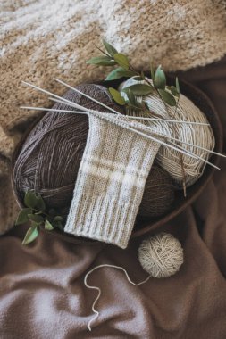 El örgüsü çoraplar, iğneler ve iplik yumağı sepette. El yapımı ve yavaş yaşam için higge kavramı.