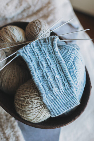 Рука вязаные носки с иголками и пряжи мяч в корзине. Мбаппе для ручной работы и гипермедленной жизни.