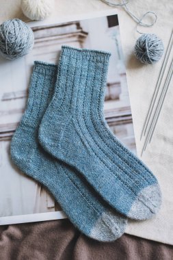 Hand knitted socks with needles and yarn balls. Concept for handmade and hygge slow life.