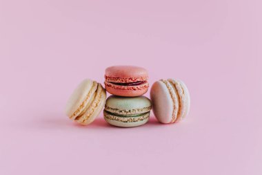 Pembe pastel arka planda lezzetli Fransız kurabiyeleri. Metin için yer.