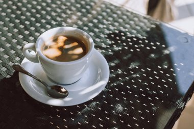 Sokak kafesindeki bir masada bir fincan sade kahve. Seçici odaklanma. Metin için yer.