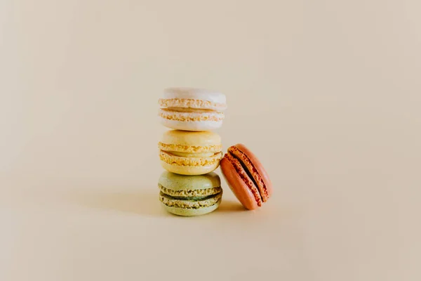 stock image Tasty french macarons on a peach pastel background. Place for text.