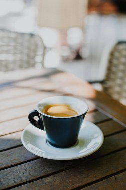 Sokak kafesindeki bir masada bir fincan sade kahve. Seçici odaklanma. Metin için yer.