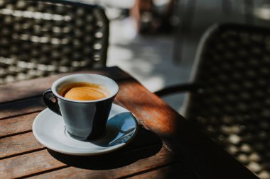 Sokak kafesindeki bir masada bir fincan sade kahve. Seçici odaklanma. Metin için yer.