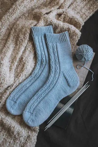 Hand knitted socks with needles and yarn balls. Concept for handmade and hygge slow life.