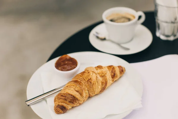 Eine Tasse Schwarzen Kaffee Und Ein Croissant Auf Einem Tisch — Stockfoto