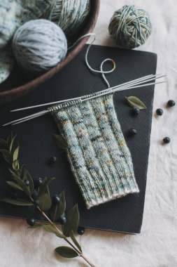 El örgüsü çoraplar, iğneler ve iplik yumağı sepette. El yapımı ve yavaş yaşam için higge kavramı.