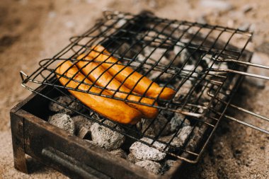 Delicious grilled sausage on a barbecue. Picnic menu. Selective focus.