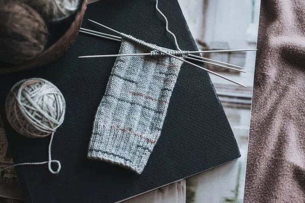 El örgüsü çoraplar, iğneler ve iplik yumağı sepette. El yapımı ve yavaş yaşam için higge kavramı.