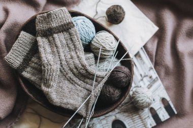 El örgüsü çoraplar, iğneler ve iplik yumağı sepette. El yapımı ve yavaş yaşam için higge kavramı.