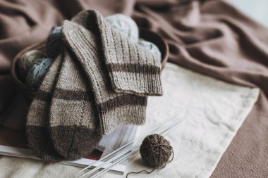El örgüsü çoraplar, iğneler ve iplik yumağı sepette. El yapımı ve yavaş yaşam için higge kavramı.