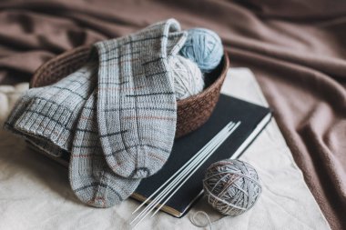 El örgüsü çoraplar, iğneler ve iplik yumağı sepette. El yapımı ve yavaş yaşam için higge kavramı.